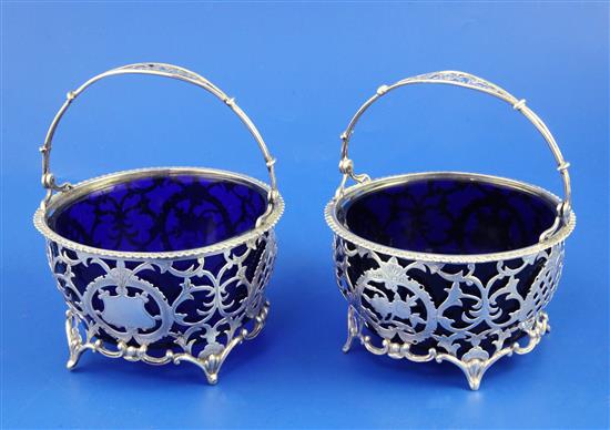 A matched pair of early 20th century pierced silver circular bonbon baskets and liners, dia. 4.25in.